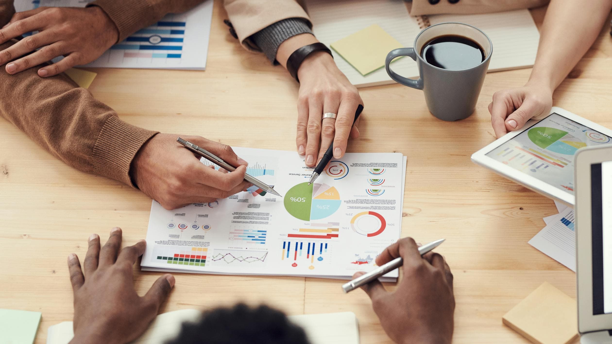Diverse team reviewing data and documents around a conference table